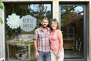 Ein Mann und eine Frau stehen vor einem Laden mit Schaufenster.