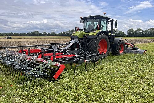 Ein Traktor mit Bodenbearbeitungsgerät. 