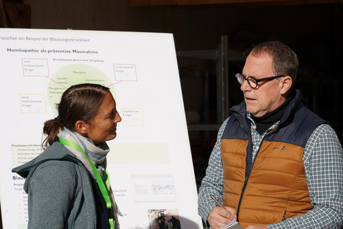 Eine Frau diskutiert mit einem Mann vor einem Flipchart.