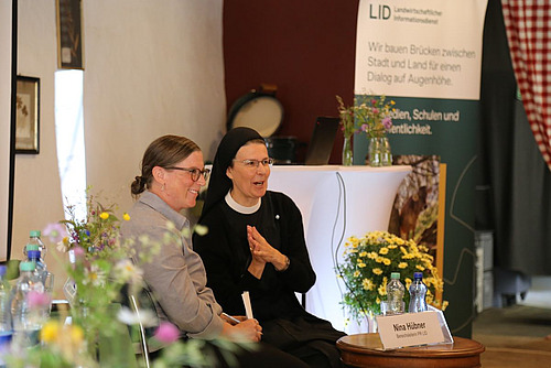 Eine Klosterfrau und eine Interviewerin sprechen miteinander.