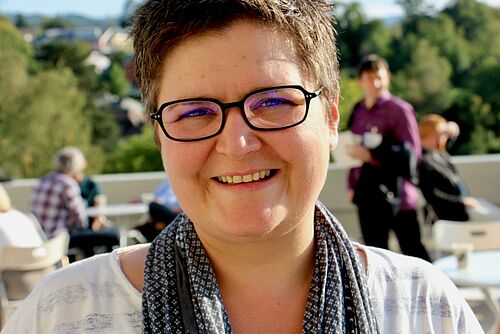 Eine Frau mit Brille lächelt in die Kamera.