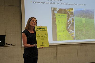 Sabine Haller präsentiert eine gelbe Tafel.