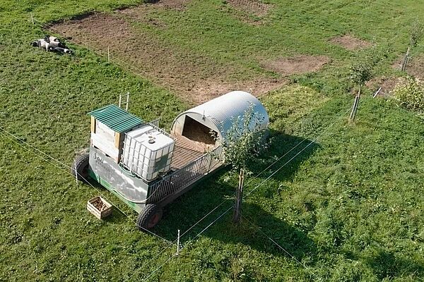 Videoscreenshot, welches den Sau Karavan auf der Wiese zeigt.