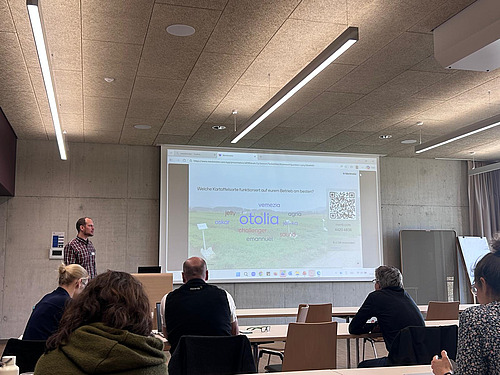 Tobias Gelencsér präsentiert eine Folie an einer Tagung.