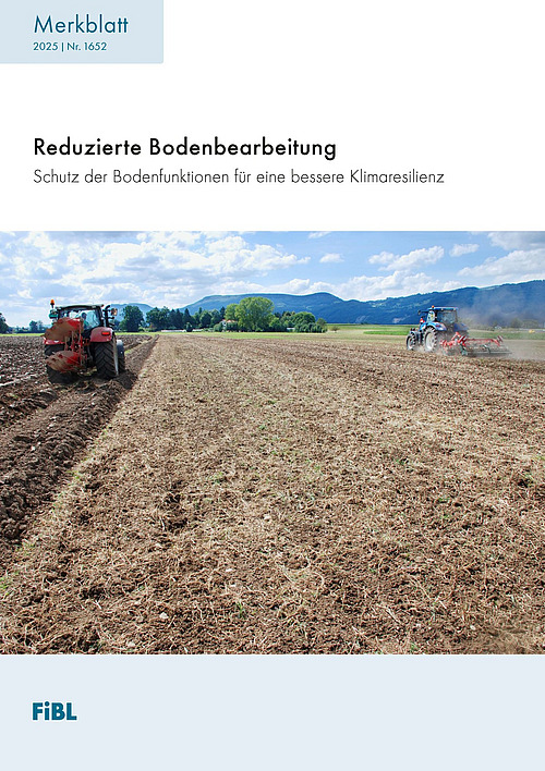 Ein Traktor fährt über ein flach bearbeitetes Feld. 