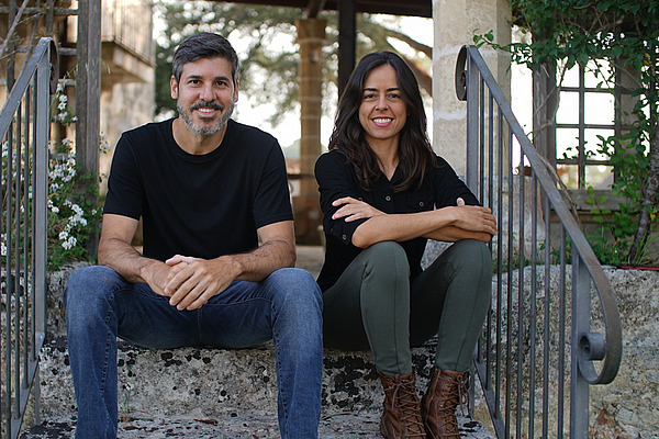 Ein Mann und eine Frau sitzen draussen auf einer Treppe.