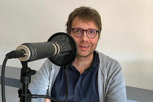 Florian Leiber hinter einem Podcast-Mikrofon