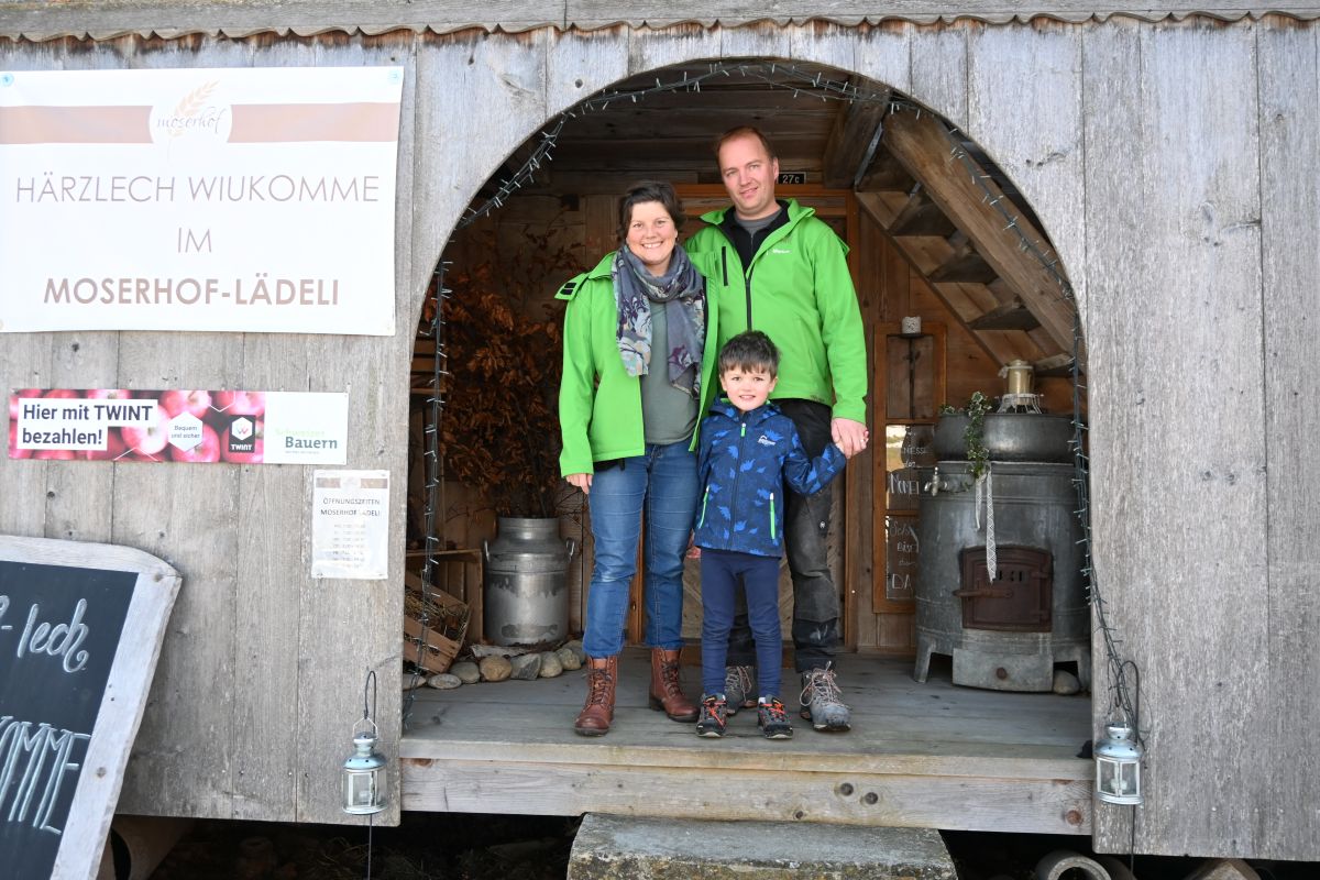 Eltern stehen mit ihrem Kind in der Tür des Hofladens.