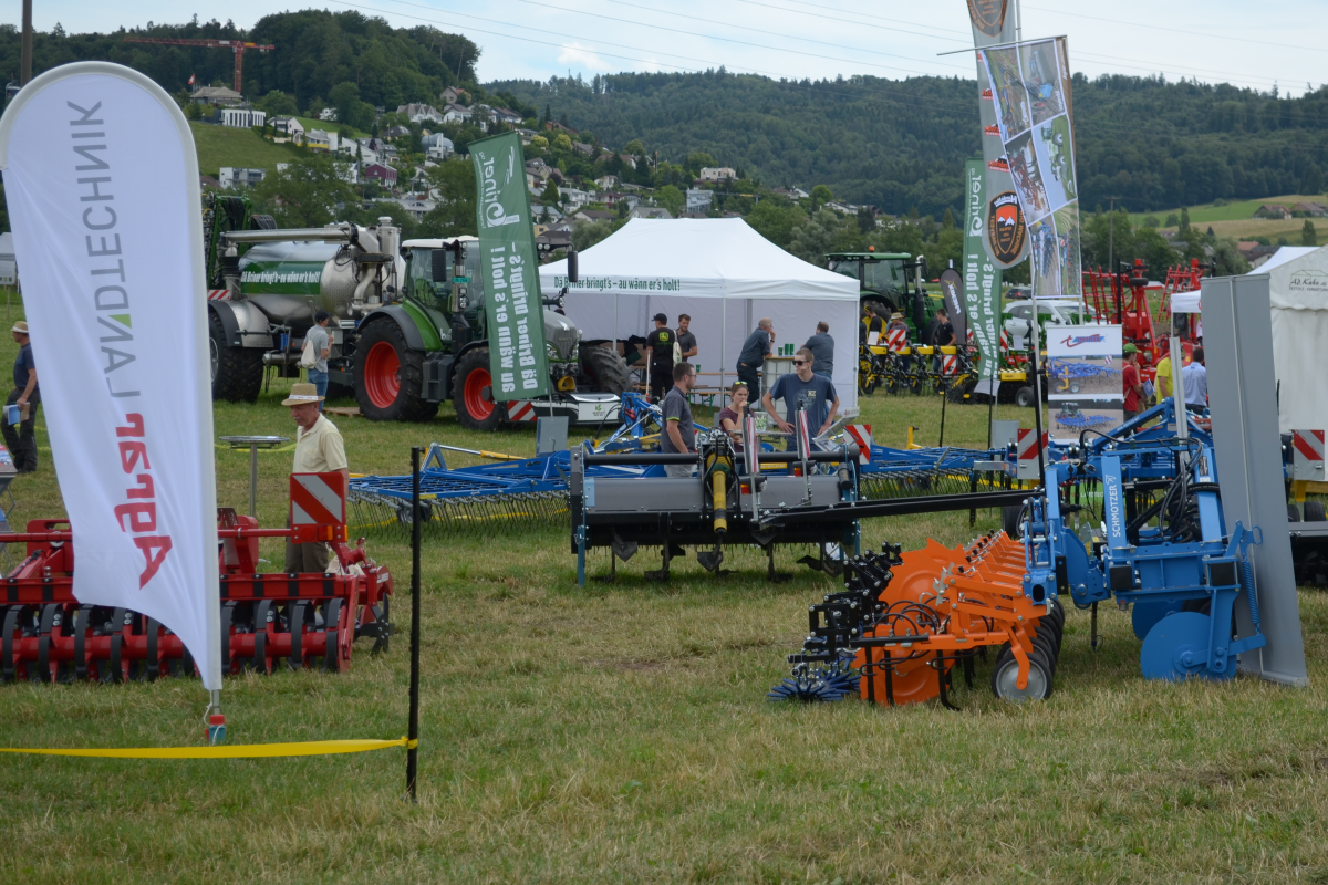 Eine Ausstellungsfläche auf einer Wiese mit verschiedenen technischen Geräten. 